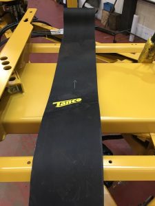 A black belt on a yellow machine<br><br>Description automatically generated with low confidence